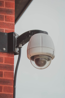 cctv security camera in the corner of a brick wall