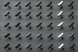 rows of black cctv cameras with one white row